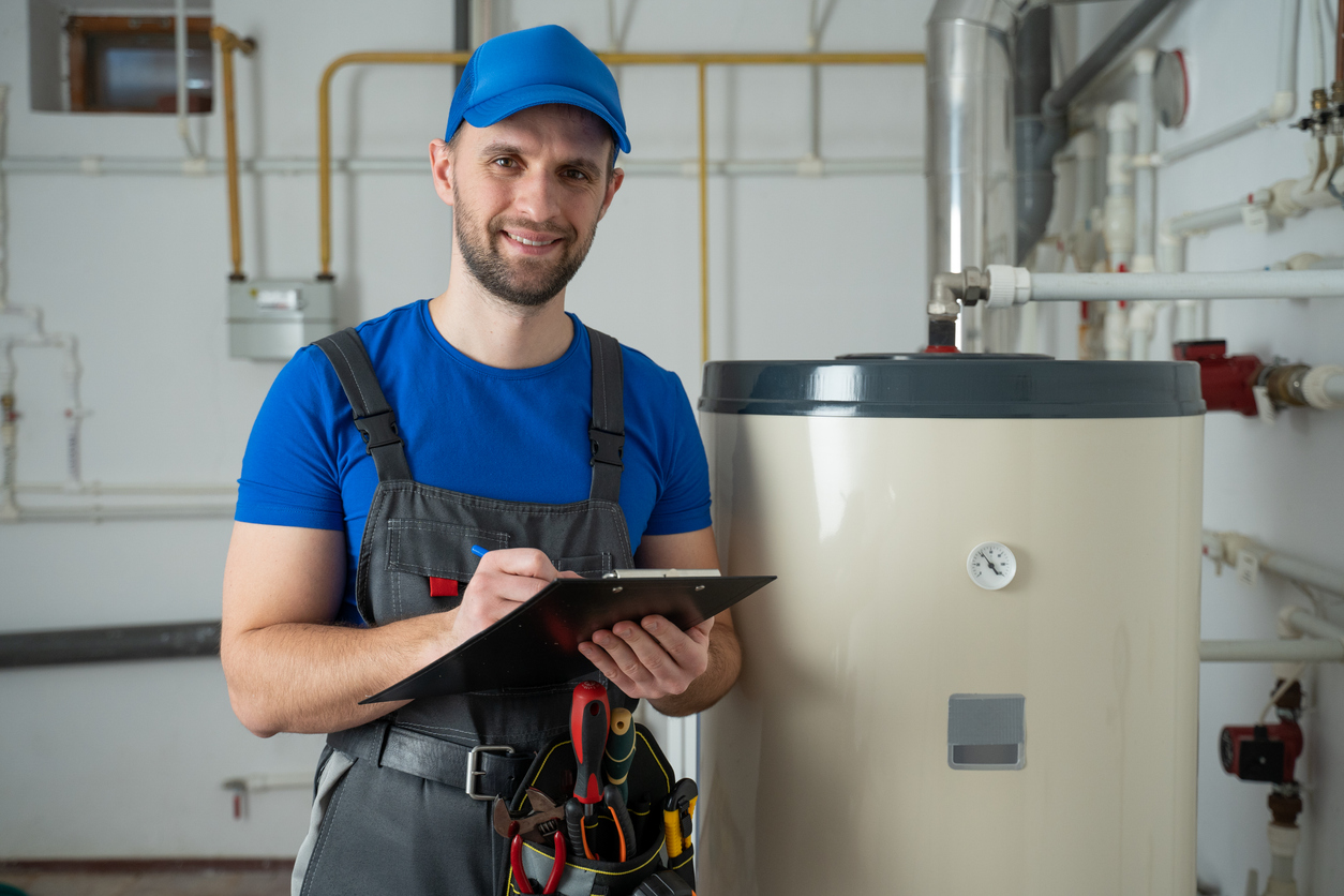 Technician servicing an hot-water heater. Man check equipment of the boiler house thermometer